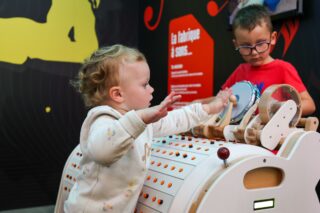 Deux enfants qui joue au module "Fabrique un son" dans le coin des enfants