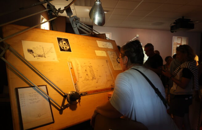 1 personne qui observe des documents du Radôme dans le parcours immersif